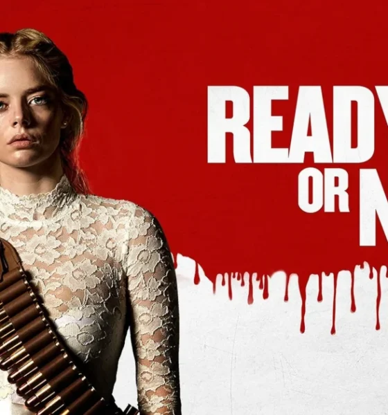 romotional banner for the 2019 horror-comedy film "Ready or Not." A young blonde woman in a torn white lace wedding dress stands against a red background, wearing a bandolier of bullets across her chest. The film's title appears in large white text to her right, with a dripping blood effect along the bottom of the red section.