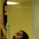 Promotional image for *Backrooms* (A24, in theaters 05.29.26), created by combining three official one-sheet posters into a single widescreen composite. Left panel: a woman with dark hair presses her hand against a yellow-green institutional wall, mouth open in terror, her face partially obscured as she peers around a corner. Center panel: the same yellow-green environment, nearly empty, with a small teal barrier visible — stark and unsettling. Right panel: a man looks upward with a fearful expression against a pale institutional wall. The Horrortainment News logo appears in the lower right corner.