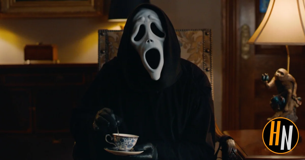 Ghostface from Scary Movie (2026) sits in an ornate, dimly lit parlor room, wearing the iconic white ghost mask and black robe, stirring a delicate blue-and-white china teacup with a black-gloved hand. A vintage lamp and a small decorative figurine are visible in the background. The Horrortainment News logo appears in the lower right corner.
